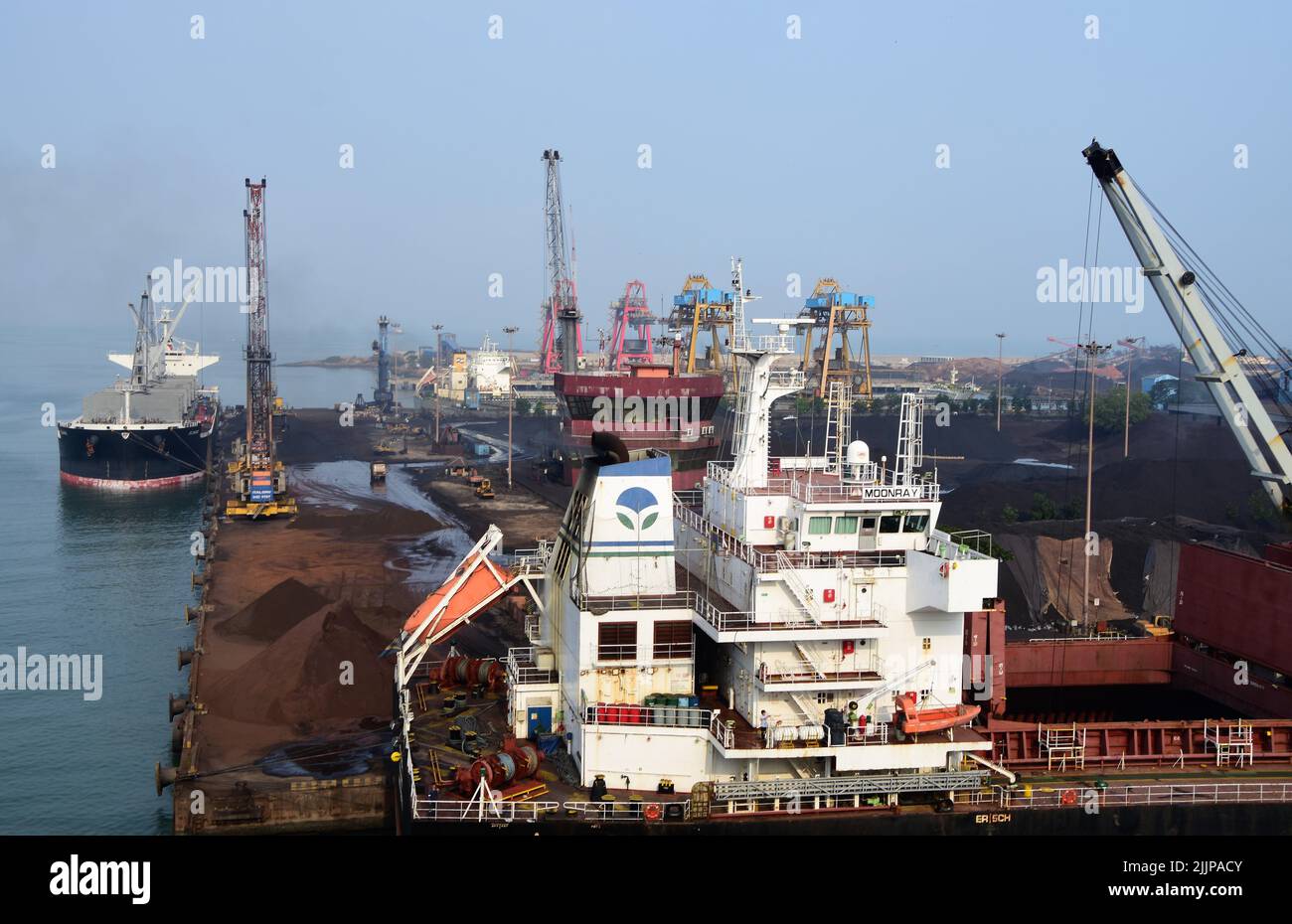 Das Bild wurde im April 2019 aufgenommen und zeigt verschiedene Kransysteme zum Be- und Entladen von Schiffen im Hafen von New Mangalore India Stockfoto