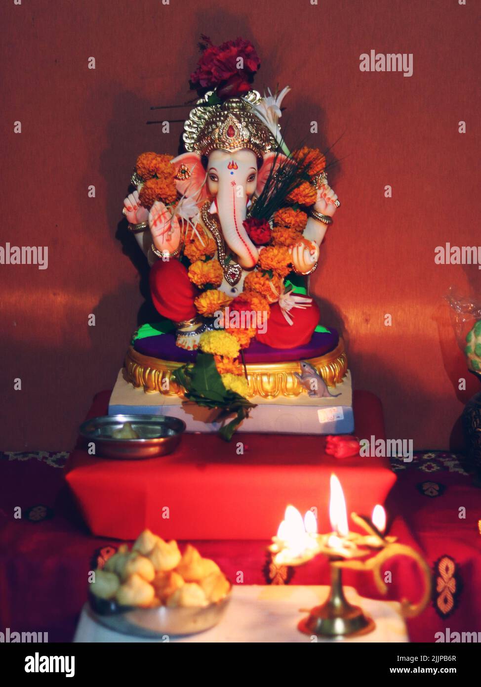 Eine vertikale Aufnahme des keramischen Lord Ganesh Idols, Ganpati, Modak und aarti Stockfoto