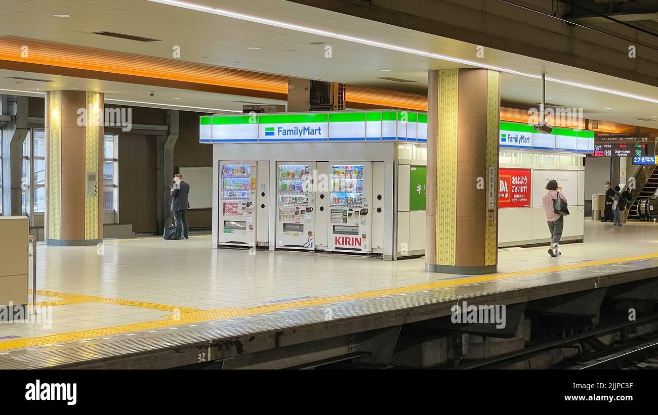 Die Rückseite eines Family Mart-Lebensmittelladens auf dem Bahnsteig der Tobu Line in der Kitasenjyu Station mit Getränkeautomaten dahinter. Stockfoto