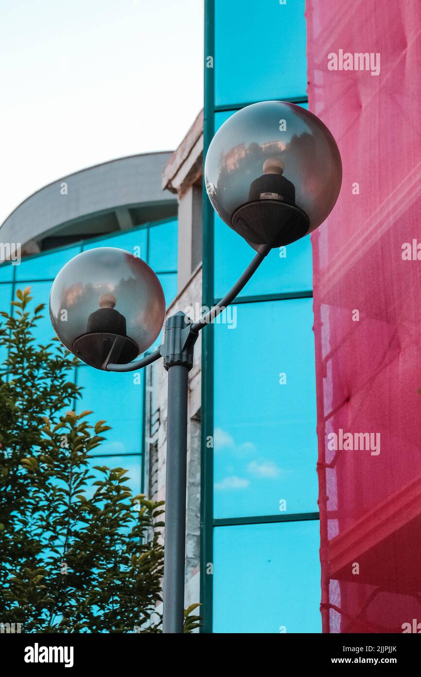Eine vertikale Aufnahme einer Straßenlaterne mit zwei kugelförmigen Gläsern, Iasi, Rumänien Stockfoto