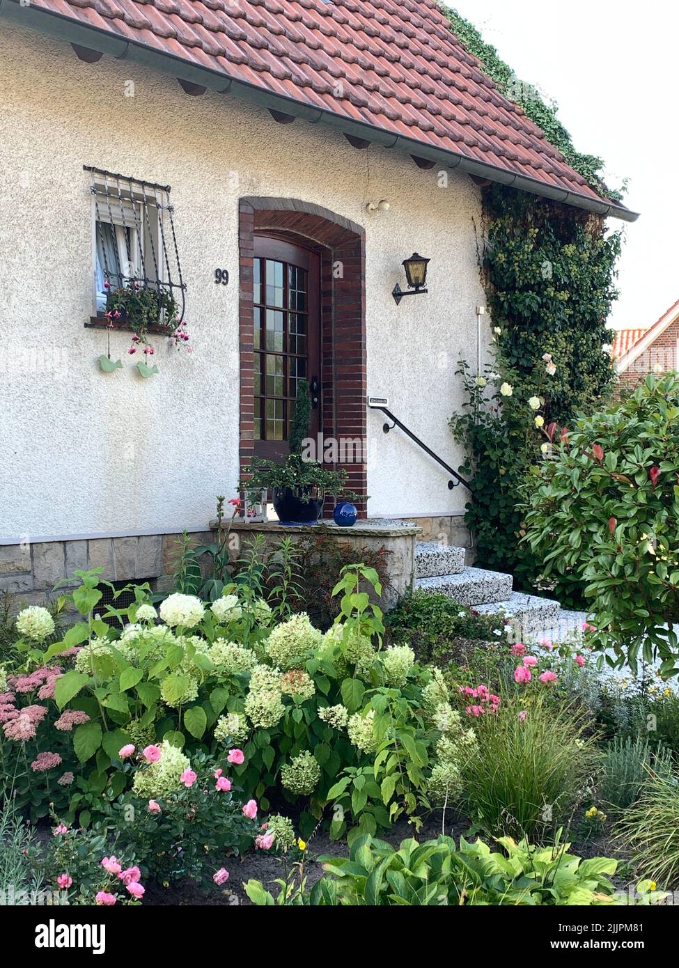 Eine vertikale Perspektive eines Hauseingangs mit seinem Garten. Stockfoto