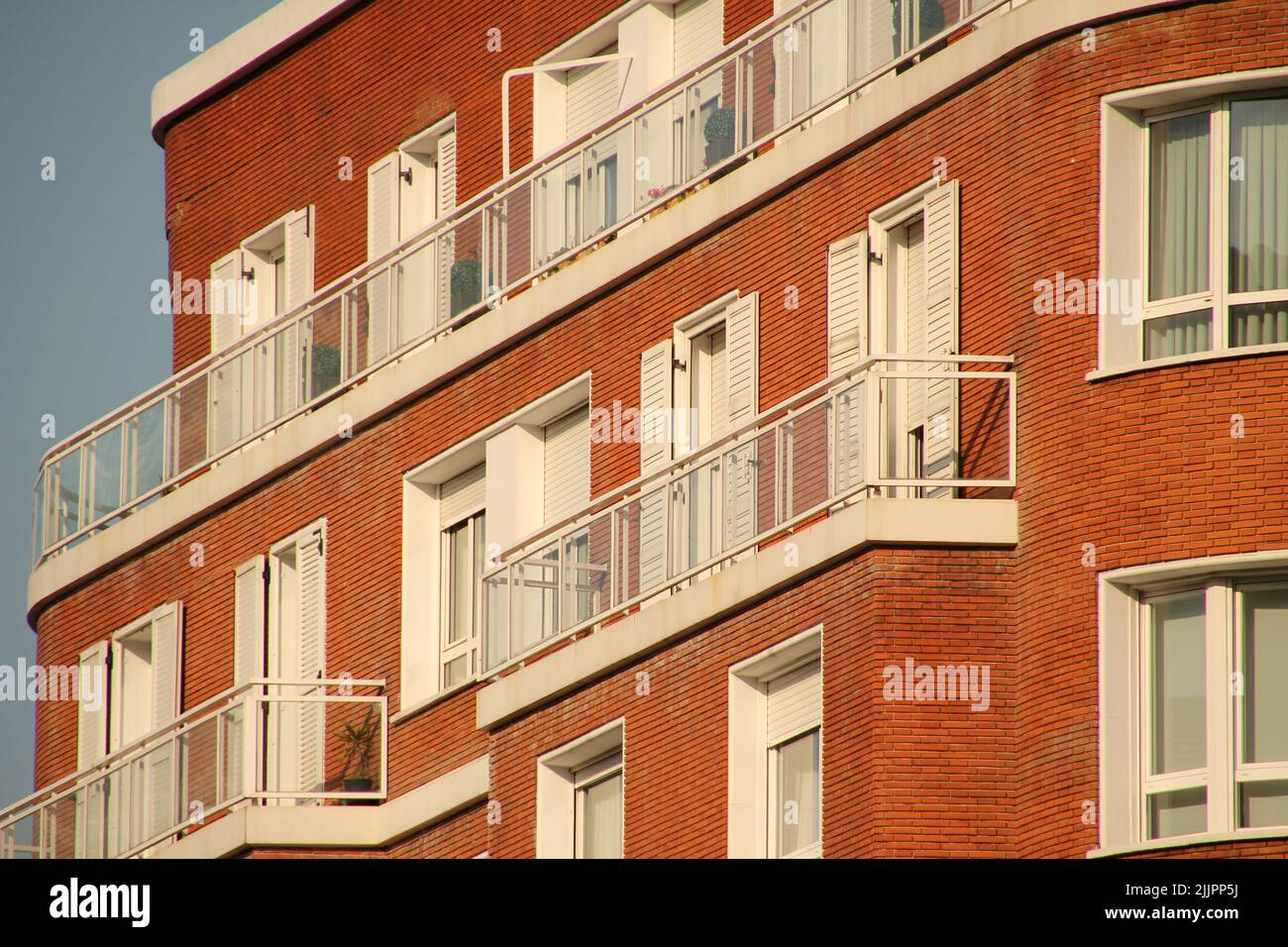 Ein rotes Backsteingebäude mit weißen Türen und Fenstern, Bilbao, Spanien Stockfoto