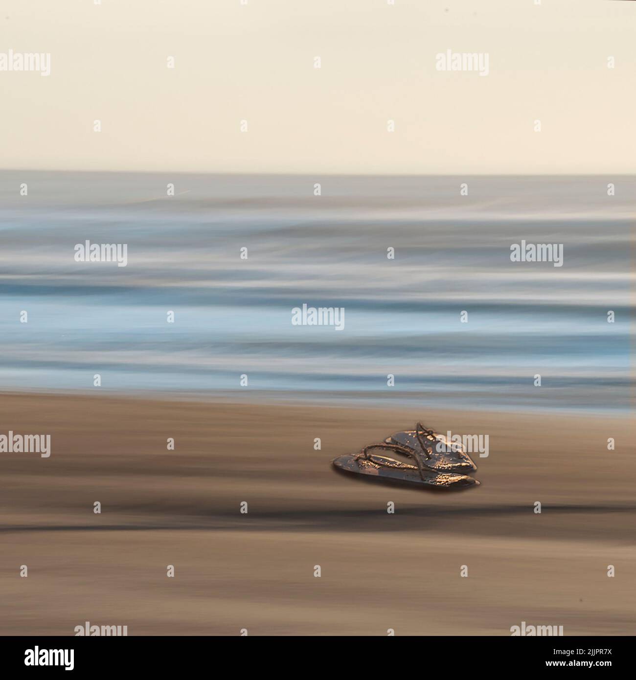 Ein Schuss Hausschuhe an einem verschwommenen Strand Stockfoto