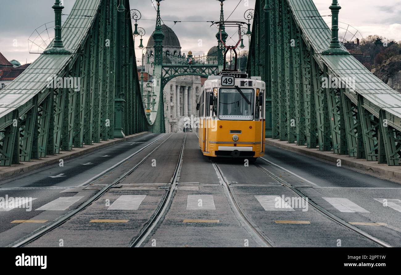 Ein Foto der Gelben Straßenbahn auf der Freiheitsbrücke in der Stadt Budapest, Ungarn. Stockfoto