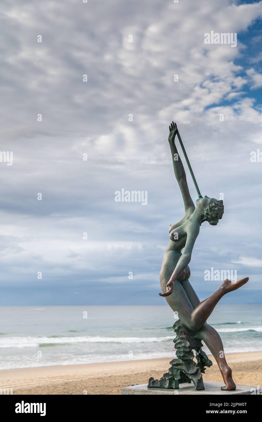 Die ikonische Bronzeskulptur „Melody on the foreshore“ mit Blick auf die Brandung im Southport Surf Club, Main Beach, Gold Coast, Queensland, Australien. Stockfoto