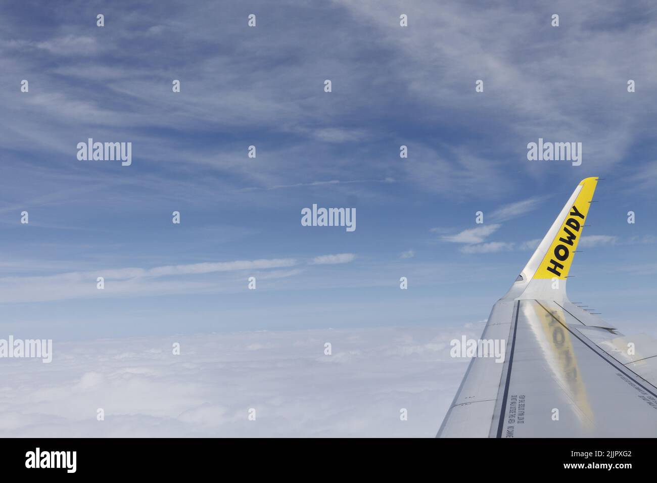 Ein Flugzeugflügel mit den Buchstaben heulend in den bewölkten Himmel Stockfoto