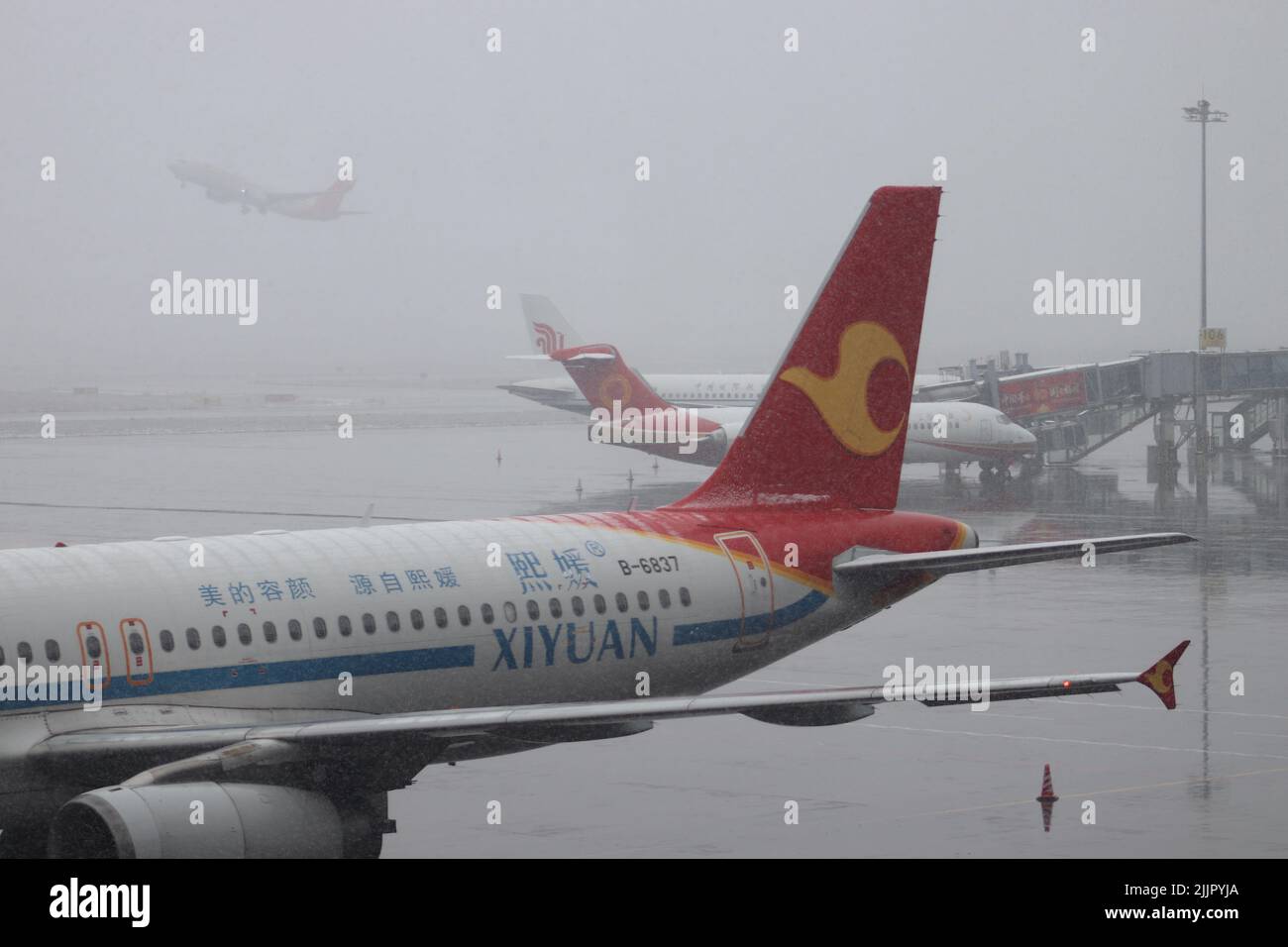 Ein Tag mit starkem Schnee am Flughafen Guiyang, China und der Enteisung von Flugzeugen Stockfoto