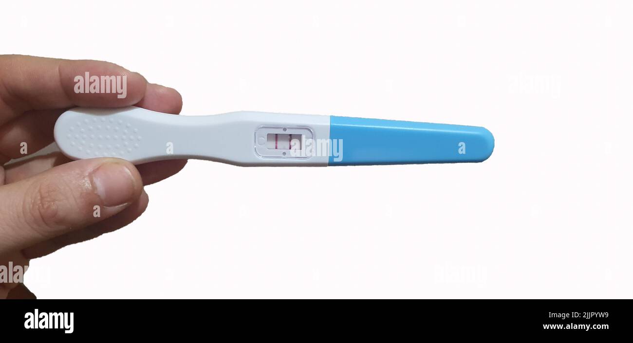 Frau Hand hält Schwangerschaftstest Frau Hand zeigt positiven Schwangerschaftstest, erwartet ein Baby Stockfoto