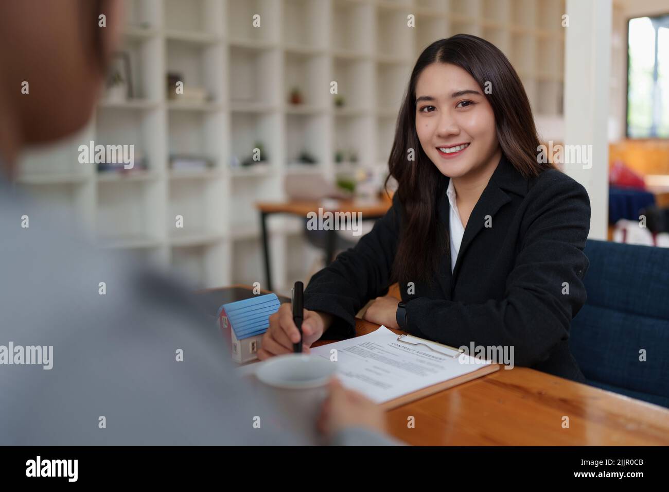 Geschäftsfrau oder Immobilienmakler Unterzeichnung Vereinbarung für den Kauf von Haus. Bankmanager und Immobilienkonzept. Stockfoto