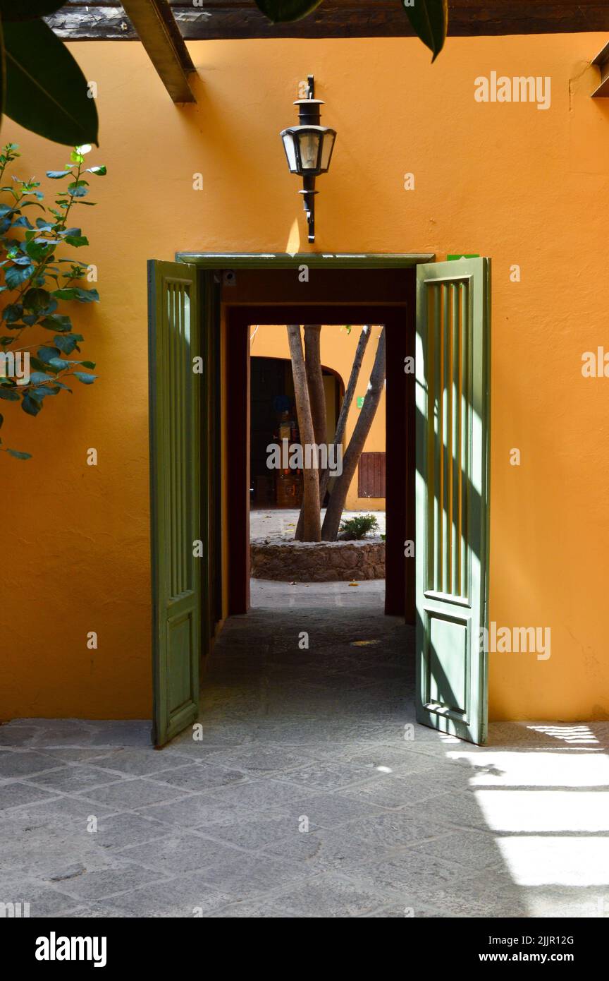 Altes Haus, orange gestrichen, mit Holztür in grün lackiert Stockfoto
