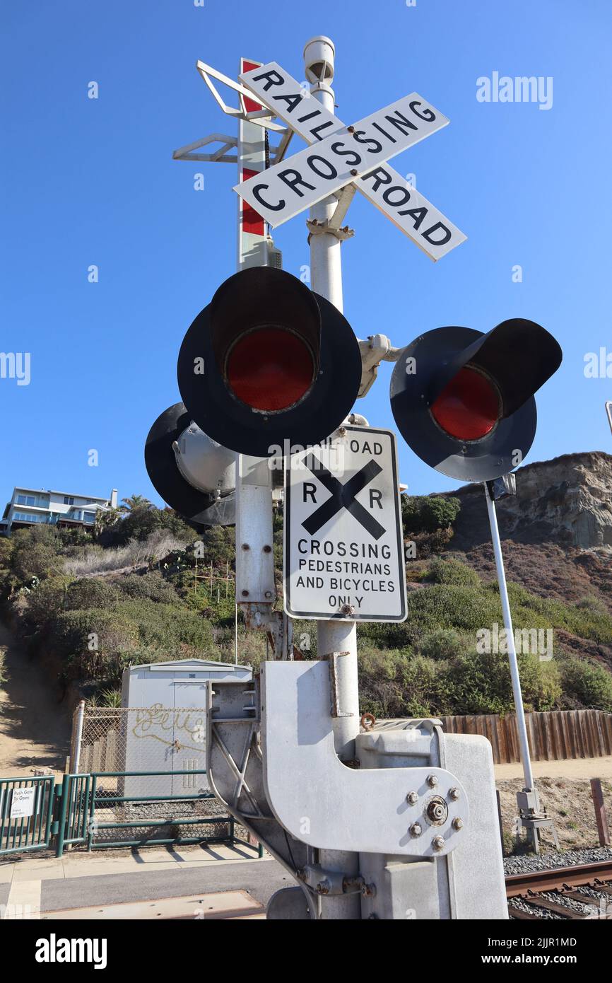 Ein vertikaler Schuss stellte das Schienenstoplight gegen einen klaren Himmel ab Stockfoto
