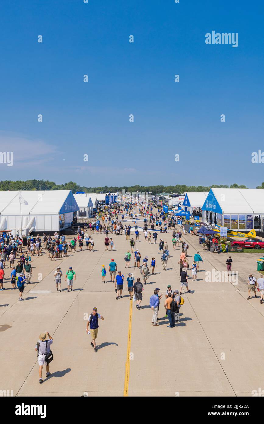 Eine vertikale Aufnahme von Besuchern, die auf der EAA AirVenture Airshow um die Landebahn laufen Stockfoto