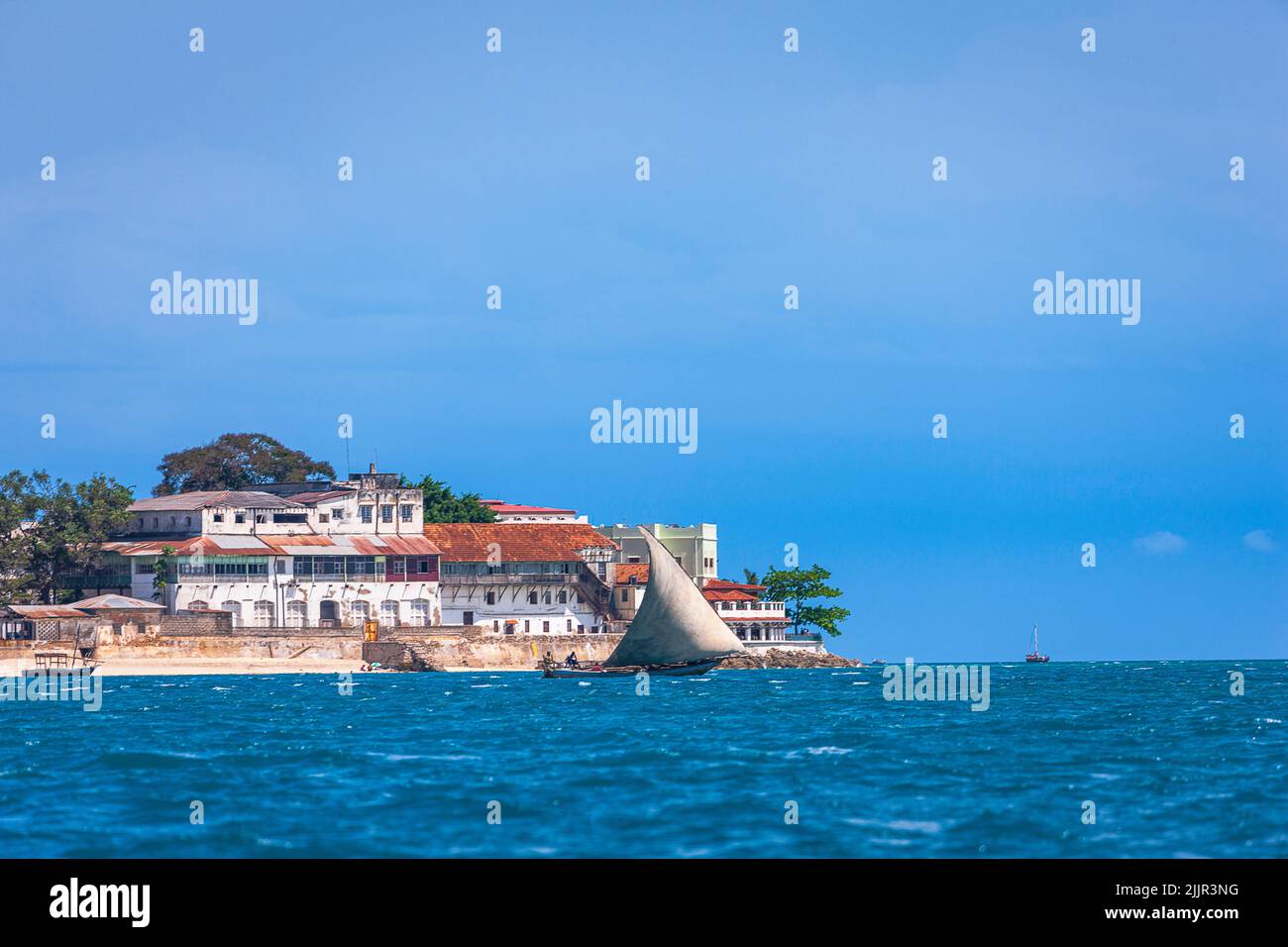 Traditionelles Fischerboot alias Faluka oder Dhow, das auf Sansibar Island, Tansania, an Stonetown vorbeifährt Stockfoto