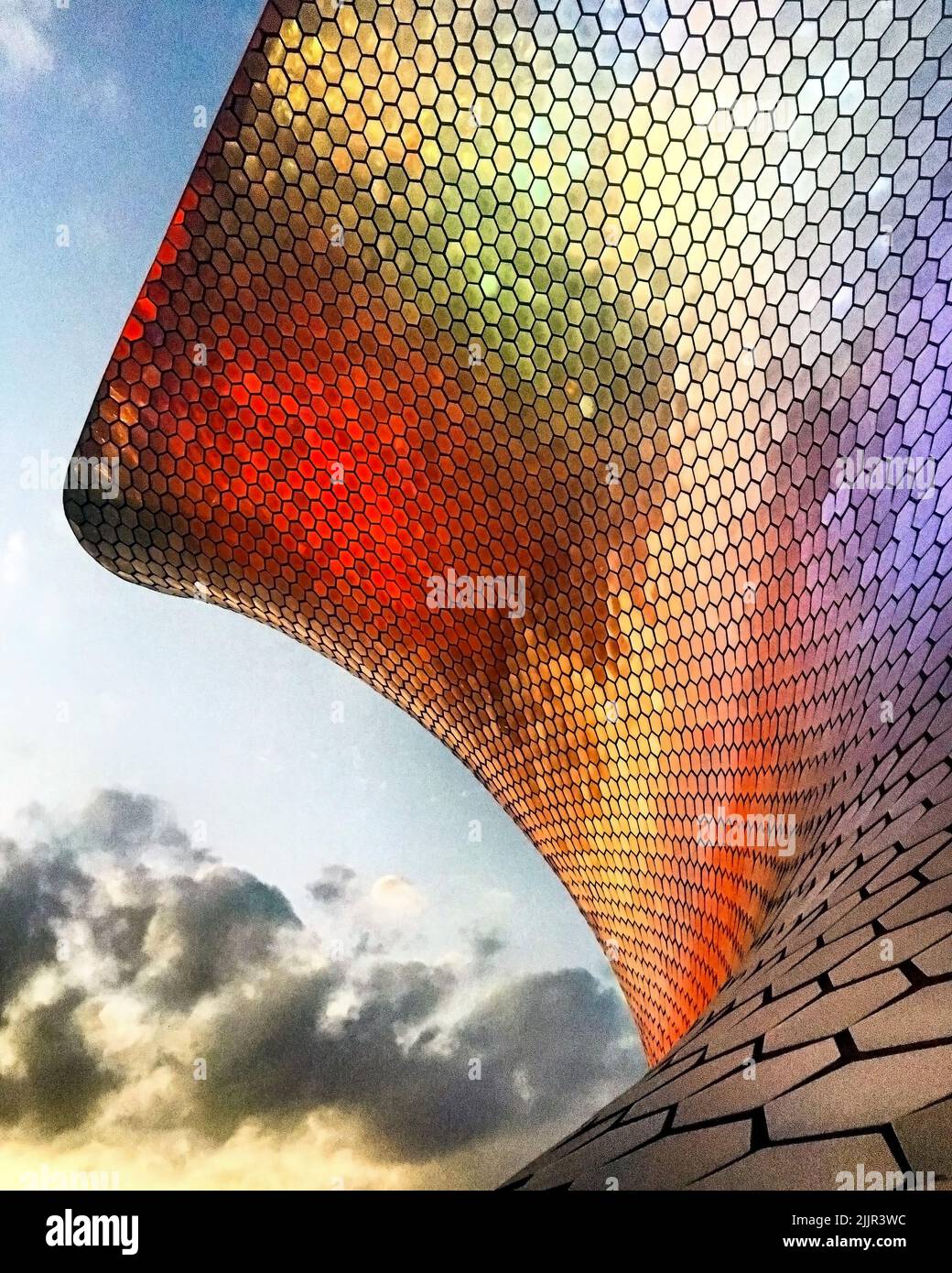 Farbliches Licht, das sich im Gitter des Museums widerspiegelt, mit Wolken und Himmel im Hintergrund Stockfoto