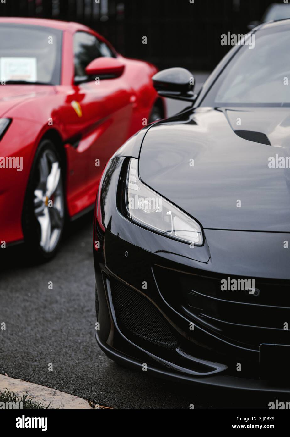 Eine vertikale Aufnahme von schwarzen und roten Ferrari-Autos im Händlergeschäft, Egham, Großbritannien Stockfoto