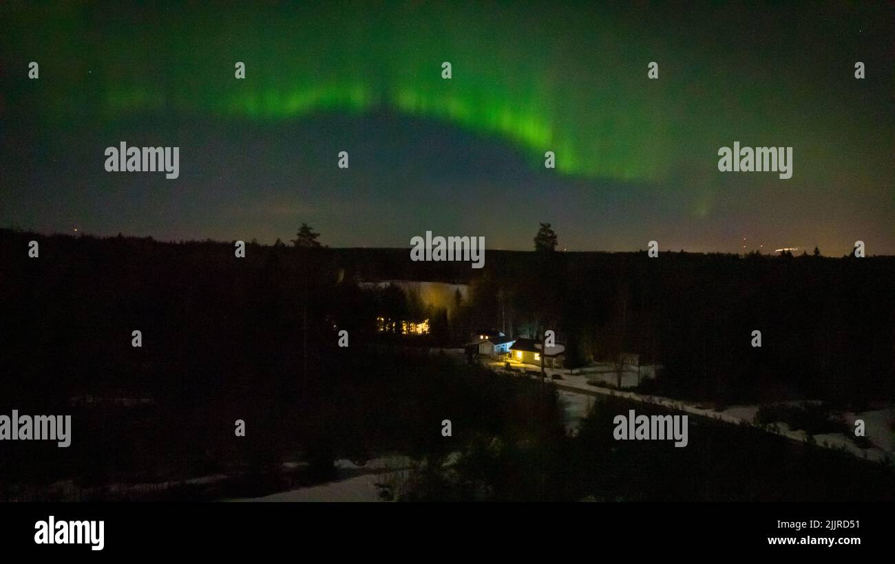 Luftaufnahme eines von Aurora Borealis beleuchteten Hauses, Nordlichter auf der Landseite Finnlands Stockfoto