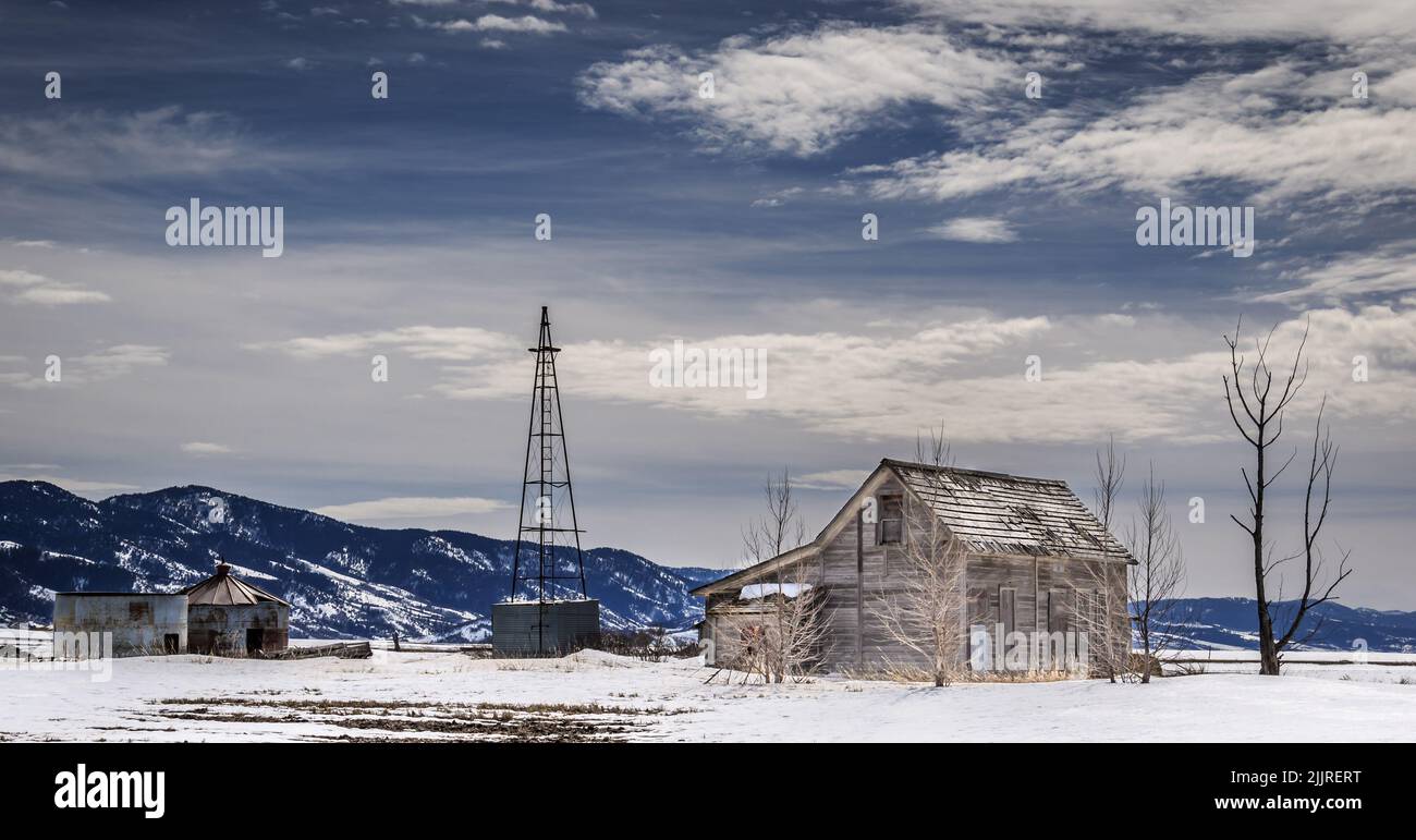 Eine Fernansicht eines verlassenen Gehöfts in einem verschneiten Feld im Südosten von Idaho, USA Stockfoto