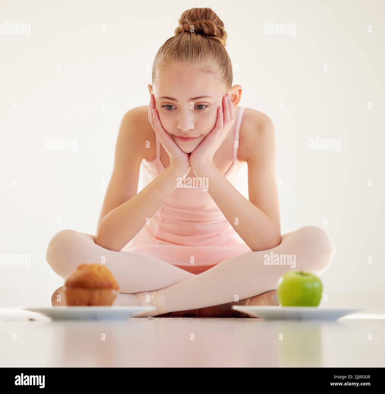 Was gut ist, ist eine gesunde Wertschätzung für das Essen. Eine junge Ballerina entscheidet, was in einem Studio zu essen. Stockfoto