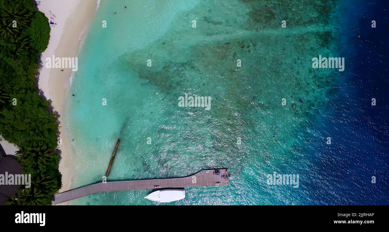 Eine Luftdrohne auf einer tropischen, unberührten Insel mit einem Pier in Südostasien und dem Ozean Stockfoto