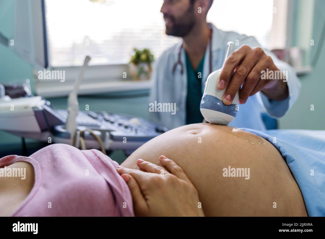 Eine Schwangerin beim Gynäkologen, die ihr Baby mit einem Ultraschallgerät untersuchen ließ. Stockfoto