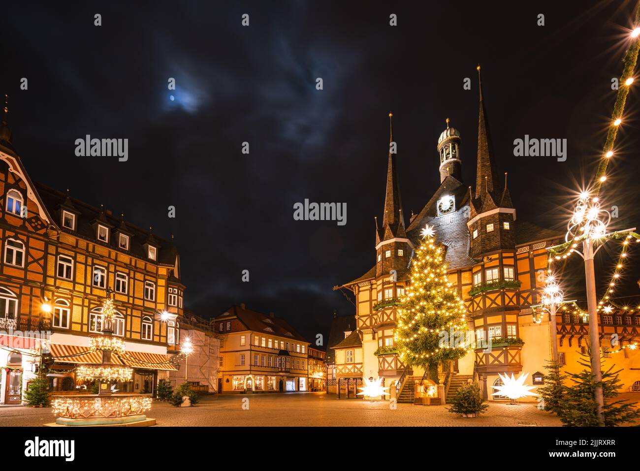 Wernigerode Rathaus in der Nacht mit Beleuchtung zur Weihnachtszeit. Himmel mit etwas Mondlicht Stockfoto