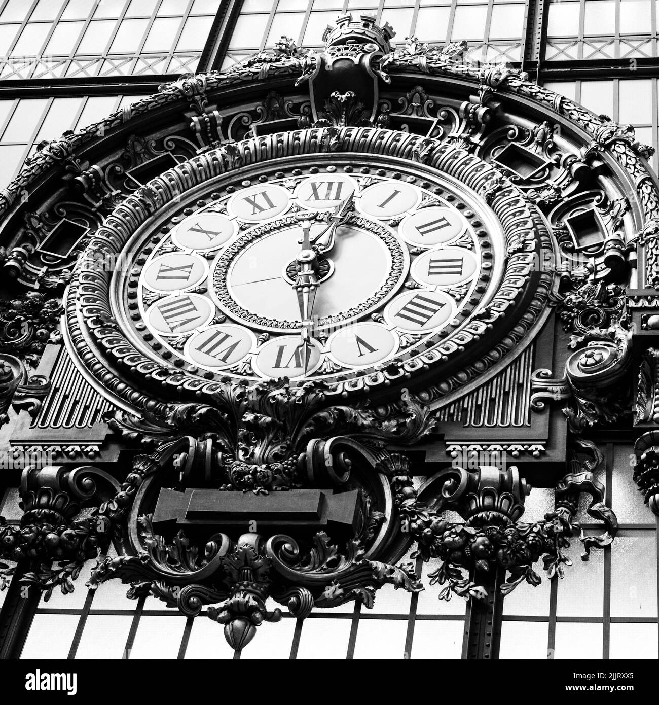 Ein niedriger Winkel einer großen ornamentierten Uhr im Museum d'Orsay in Paris, Frankreich, in Graustufen gedreht Stockfoto
