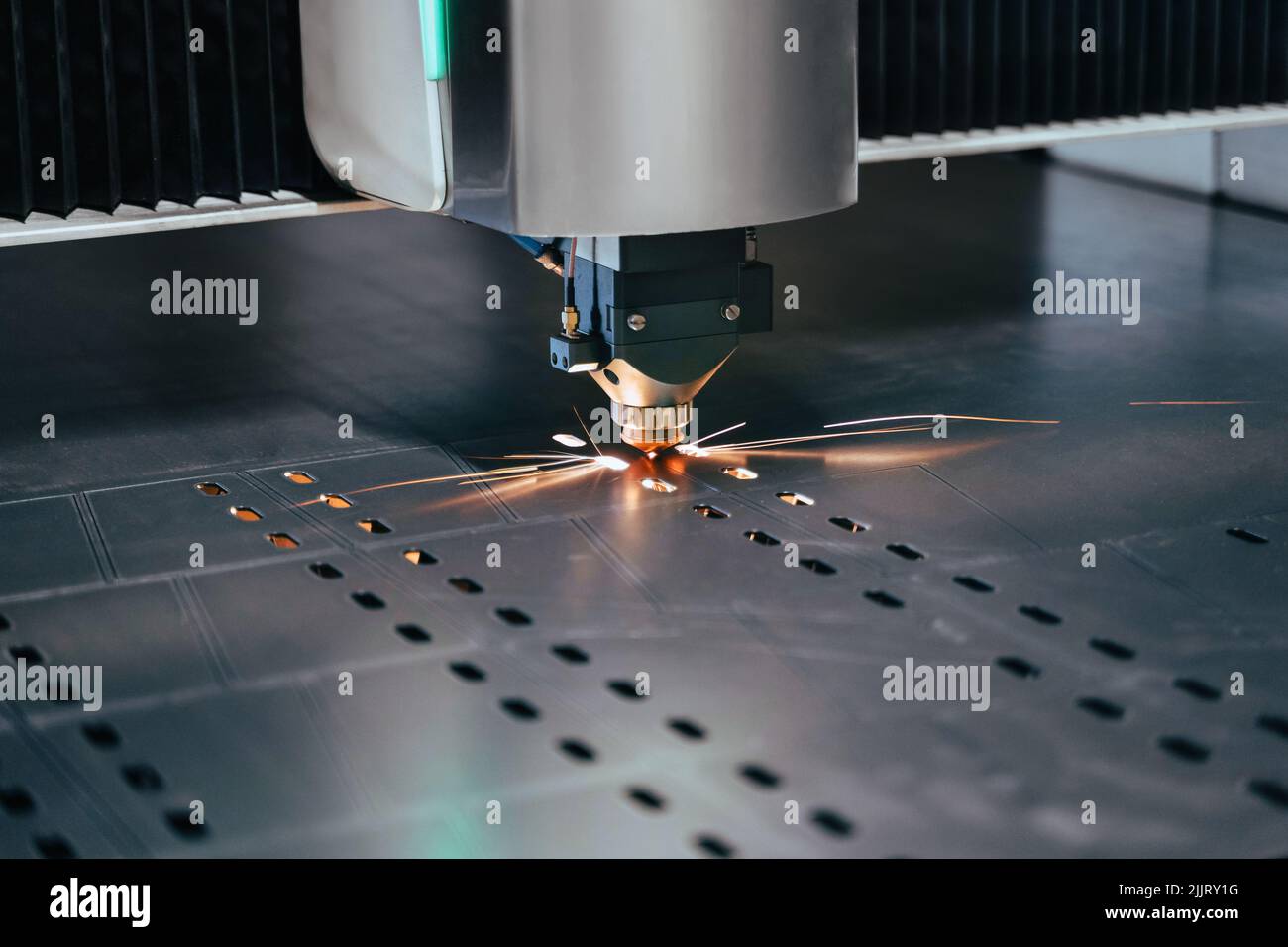 Nahaufnahme einer Laserschneidemaschine mit Funken. CNC-Plasmaschneider schneiden Metallblech. Gasschneideverfahren im Werk Stockfoto