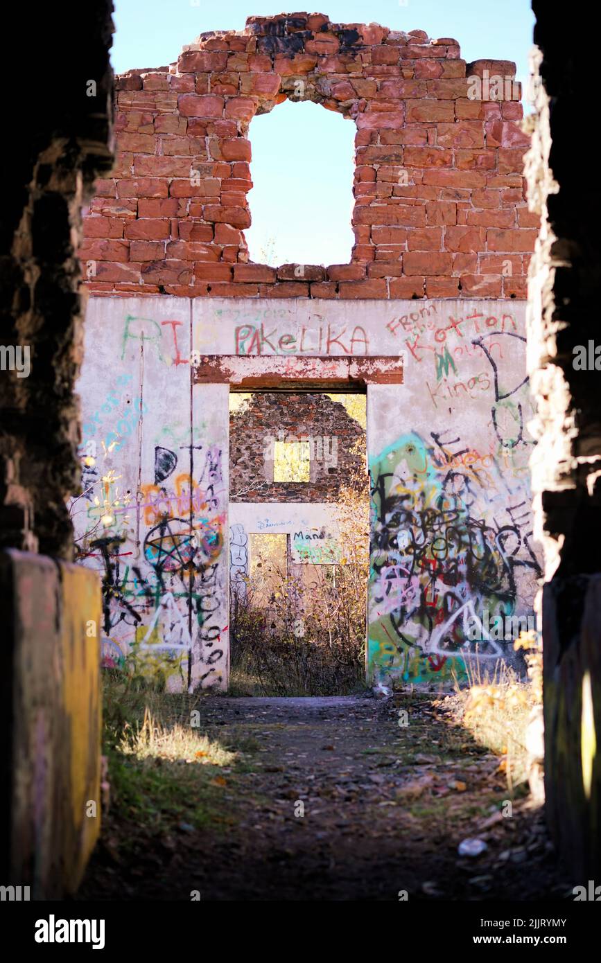 Eine vertikale Aufnahme der Ruinen einer alten Käsefabrik mit bunten Graffiti in Houghton, Michigan, USA Stockfoto