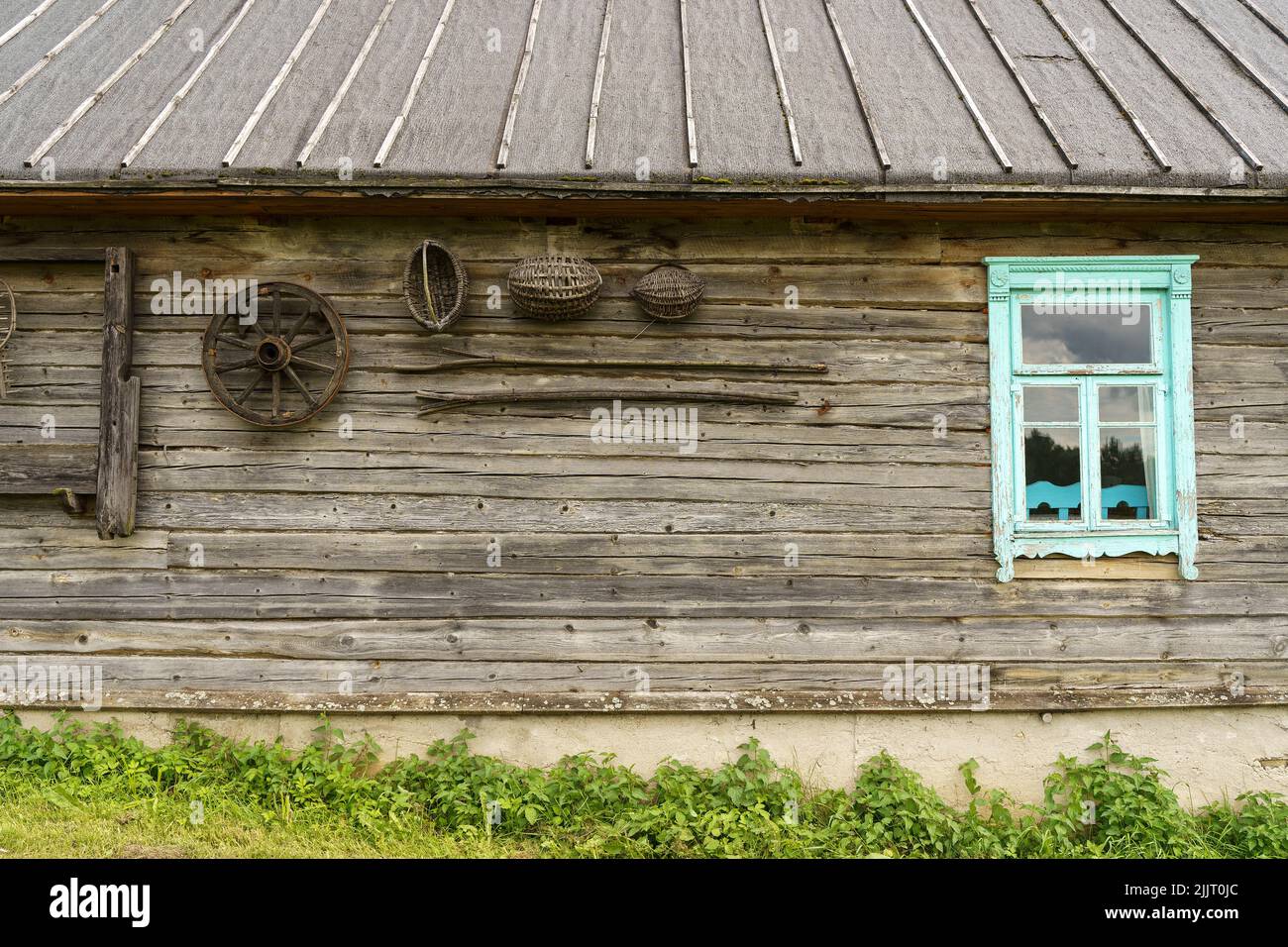 Altes Dorfhaus in der russisch-slawischen Tradition. Holzwand und Fenster mit klassischer rustikaler Architektur. Hochwertige Fotos Stockfoto