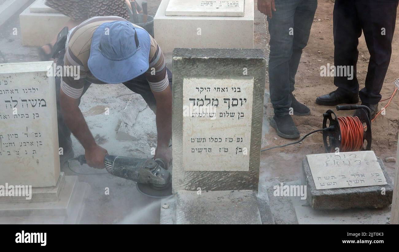 GIVATAYIM, ISRAEL - 27. JULI: Ein Arbeiter öffnet das Grab von Yosef Melamed, einem 1949 verstorbenen jemenitischen Kind, für die Entnahme einer DNA-Probe auf dem Friedhof Nahalat-Jitzhak am 27. Juli 2022 in Givatayim, Israel. Das Grab wurde geöffnet, um der Familie des Jungen zu beweisen, dass er dort begraben ist und nicht entführt und zur Adoption aufgelegt wurde. In den 1950s Jahren in Israel verschwanden jemenitische Kinder, deren Eltern behaupteten, ihre Kinder seien in der sogenannten jemenitischen KinderAffäre „entführt“ worden. Kredit: Eddie Gerald/Alamy Live Nachrichten Stockfoto