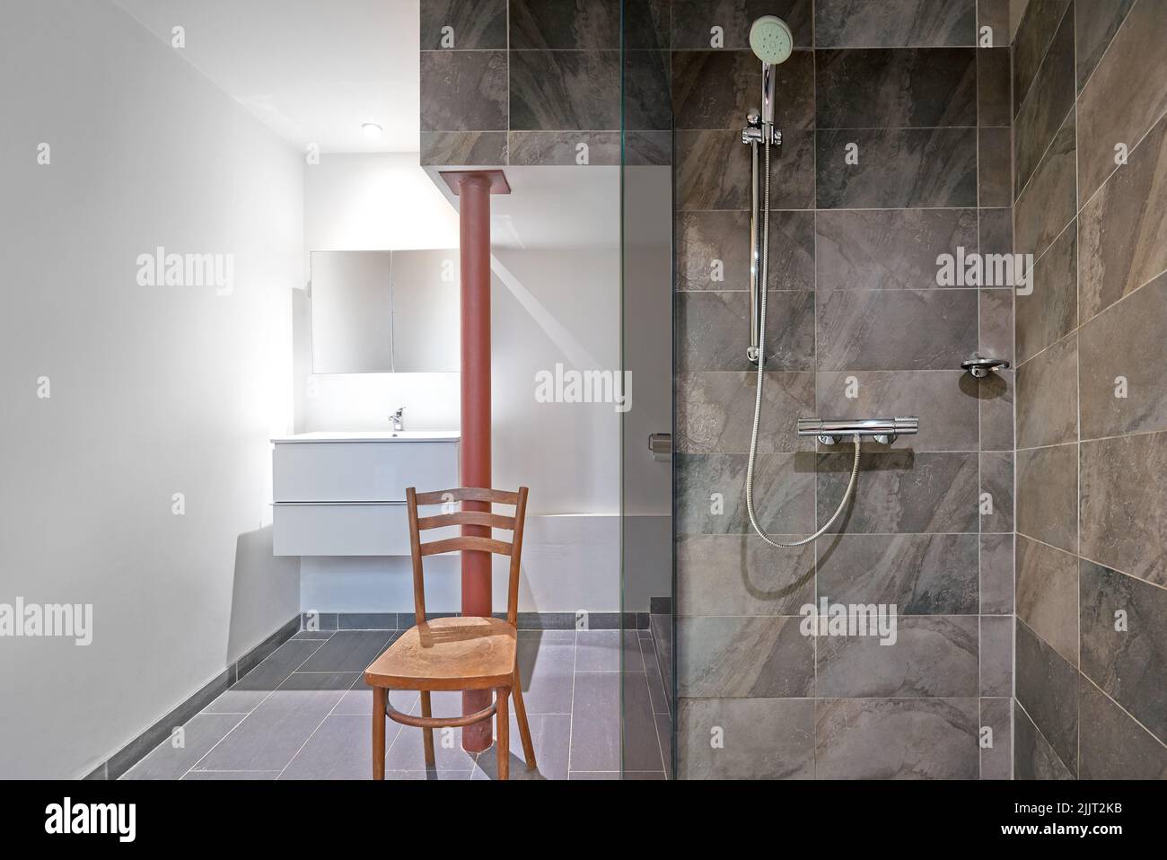 Badezimmer mit Regendusche und Steinfliesen im Badezimmer Stockfoto
