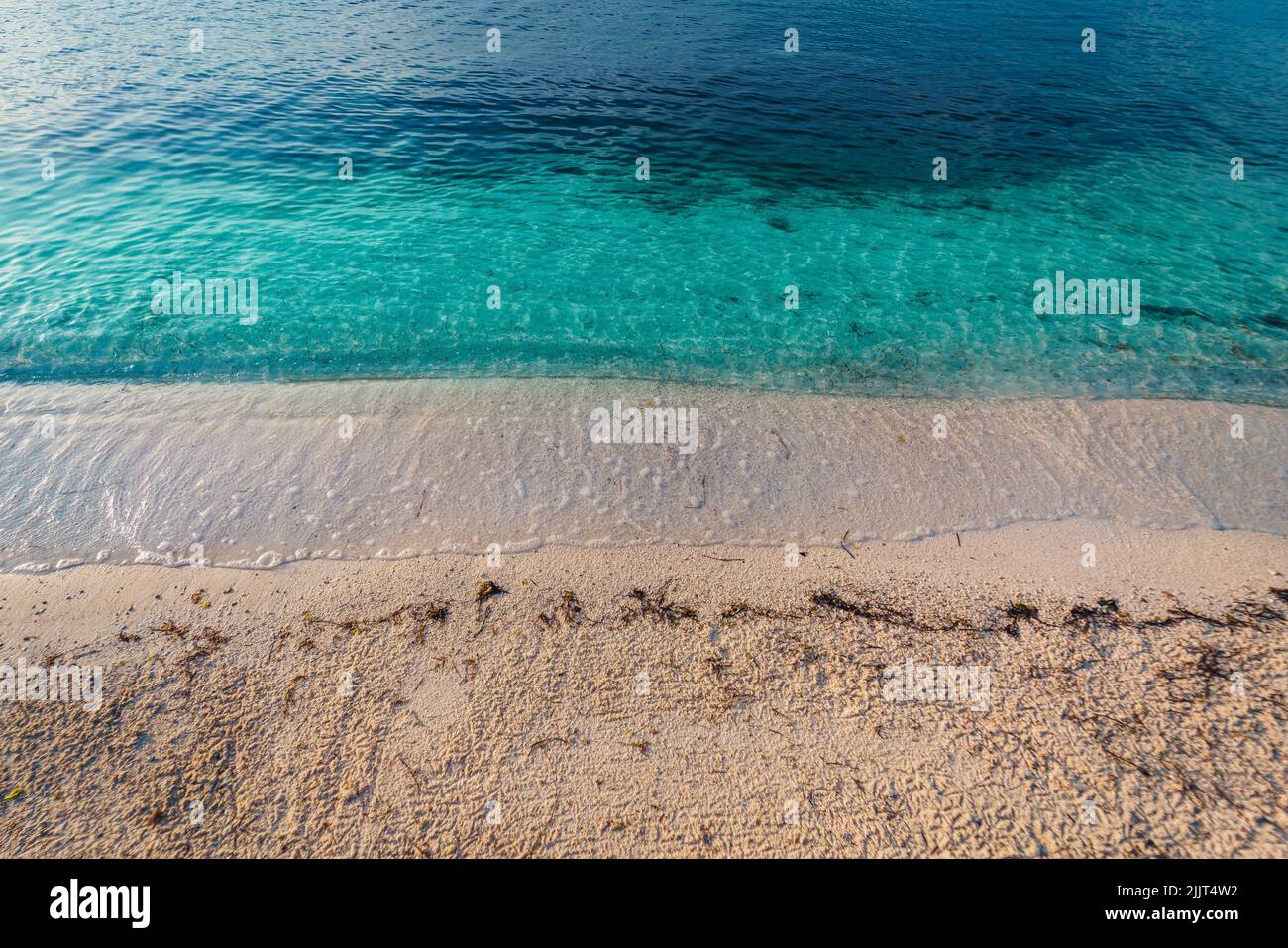 Eine schöne Aussicht auf die ruhigen Meereswellen, die den Sandstrand in der kroatischen Küste erreichen Stockfoto Eine schöne Aussicht auf die ruhigen Meereswellen, die den Sandstrand in der kroatischen Küste erreichen Stockfoto