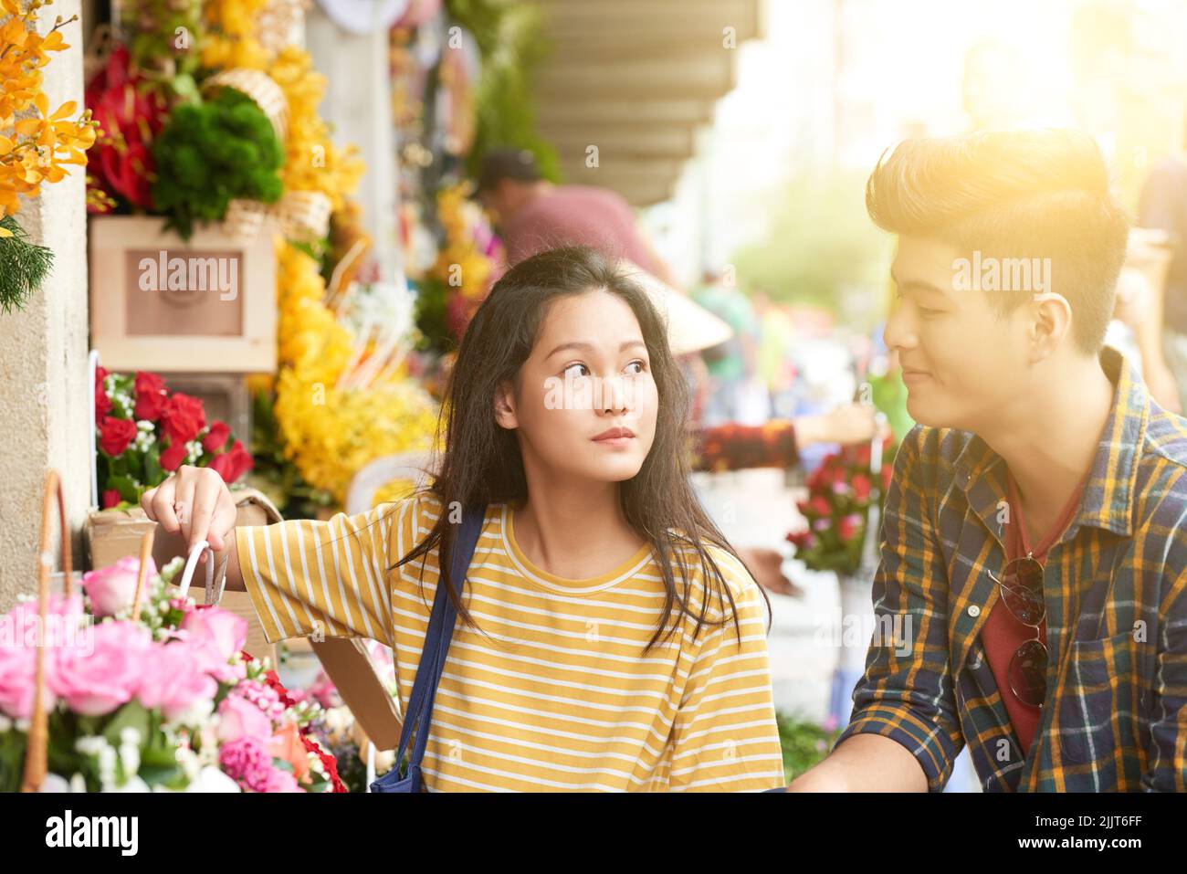 Junges vietnamesisches Paar, das Blumen auf dem Freiluftmarkt auswählt Stockfoto