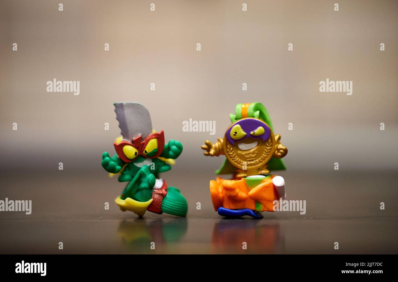 Eine Nahaufnahme von MagicBox Super Things Bösewicht Spielzeugfiguren stehen auf den Helden Stockfoto