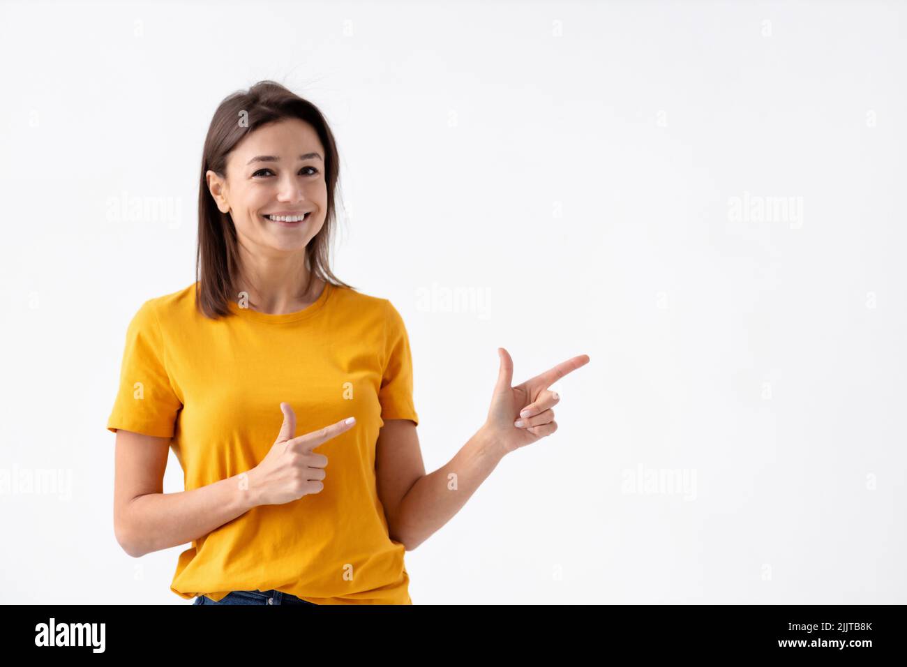 Schöne kaukasische junge Frau lächelt mit seinem Finger auf einen weißen Hintergrund zeigt Stockfoto