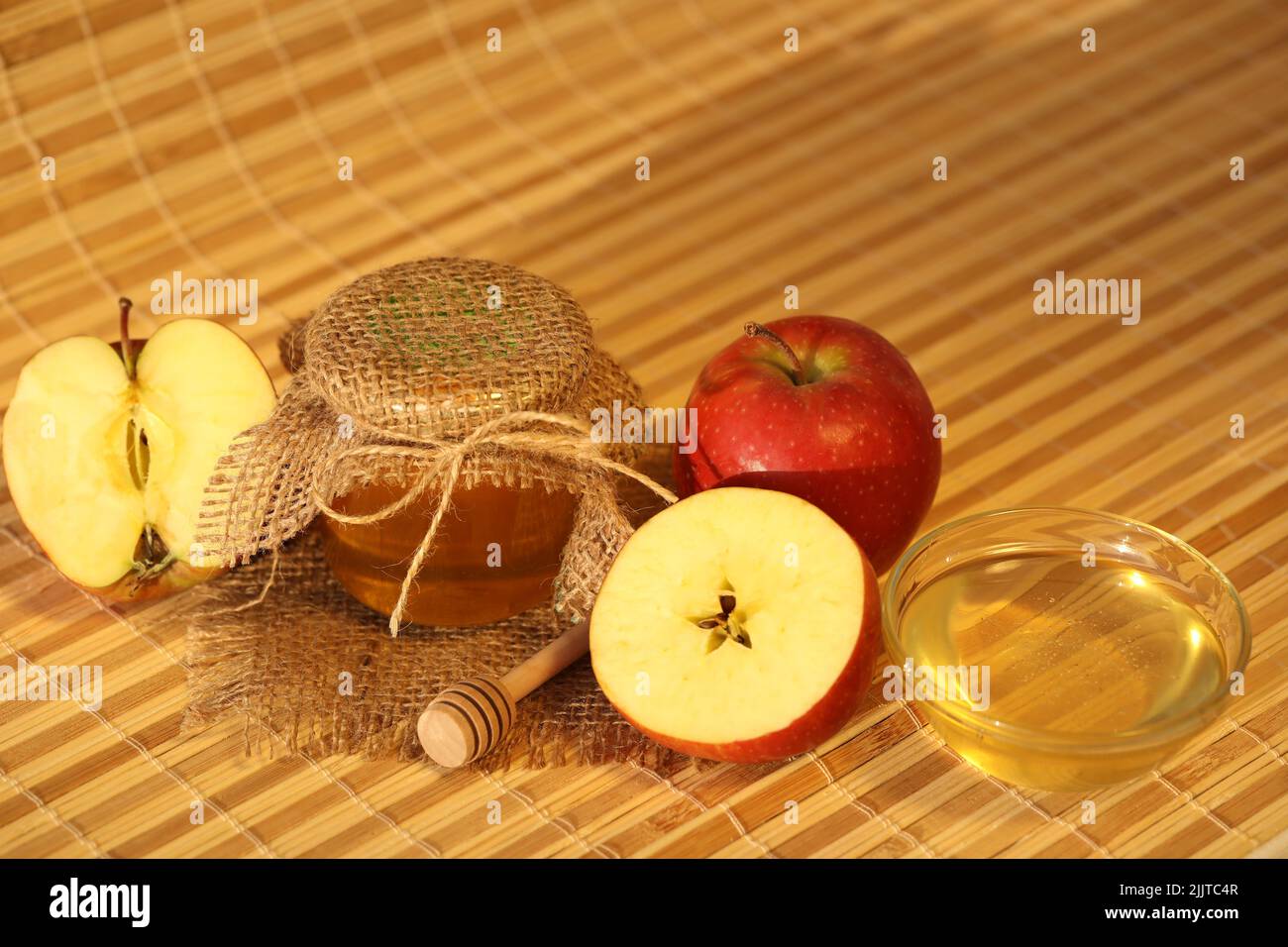 Rote frische Äpfel mit Honig auf gelbem Hintergrund mit Kopierplatz. Apfelfest Stockfoto
