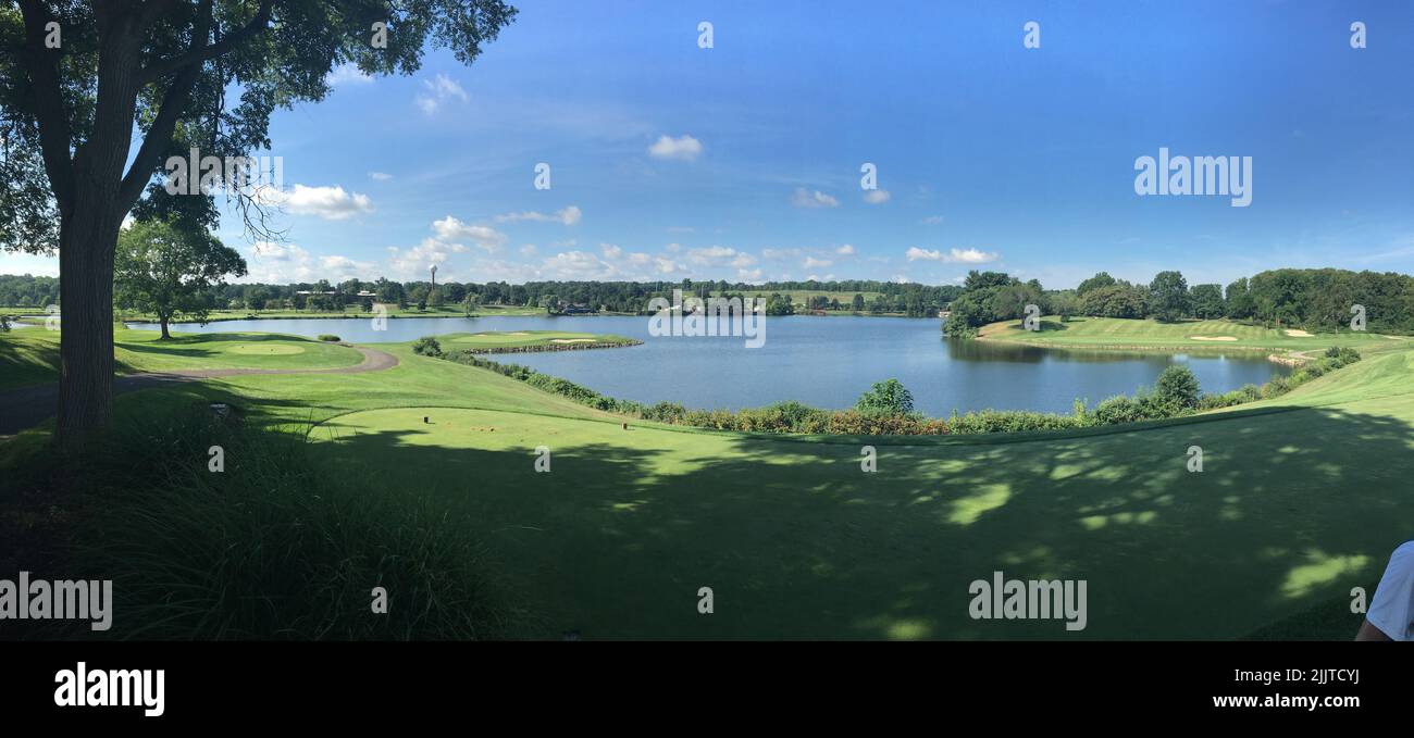 Eine Panoramaaufnahme eines Feldes im Hintergrund eines Sees Stockfoto