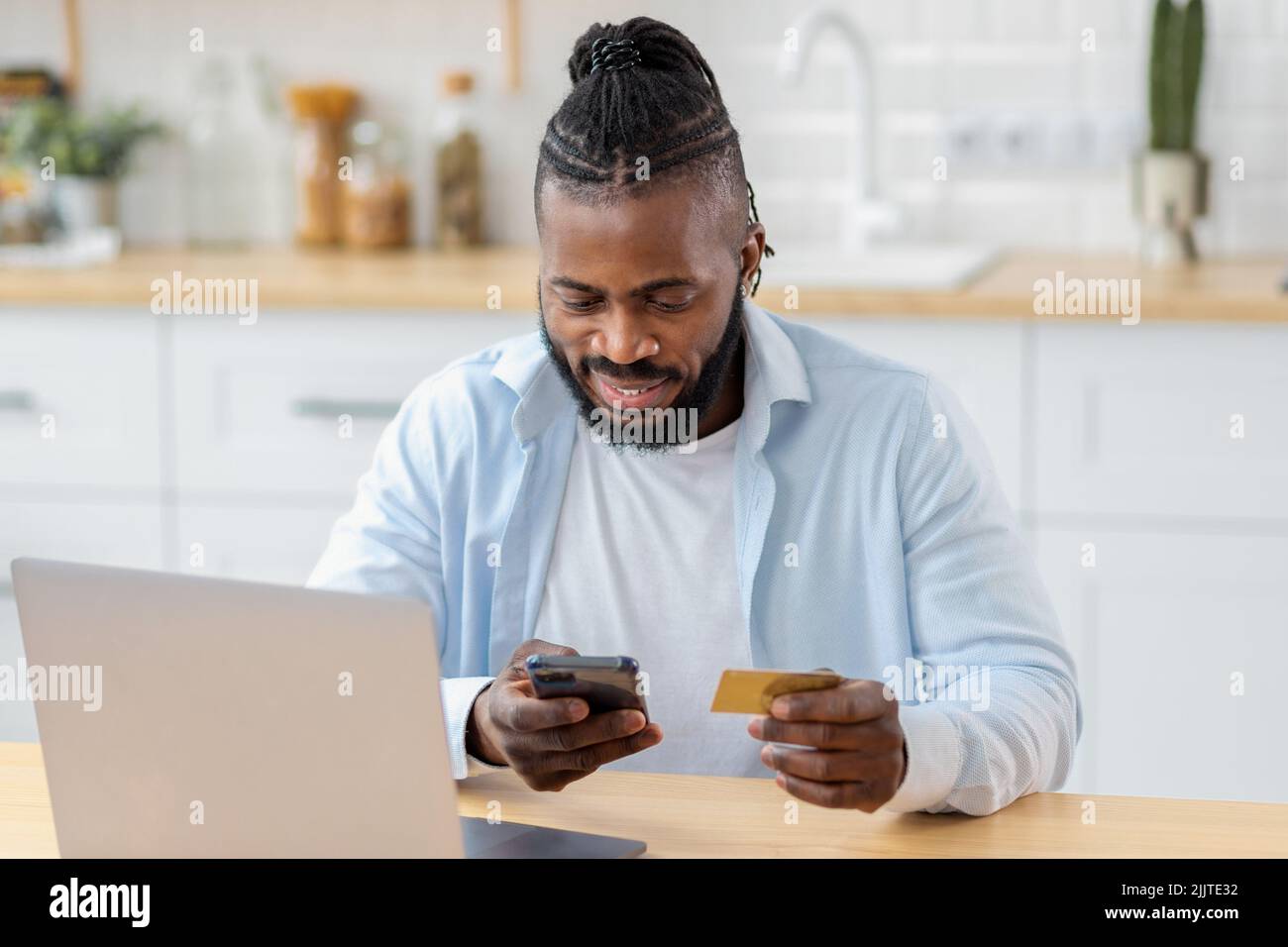 Porträt eines lächelnden Mannes nutzt sicheres Internet-Banking, um online über das Mobiltelefon für Dienste zu bezahlen Stockfoto