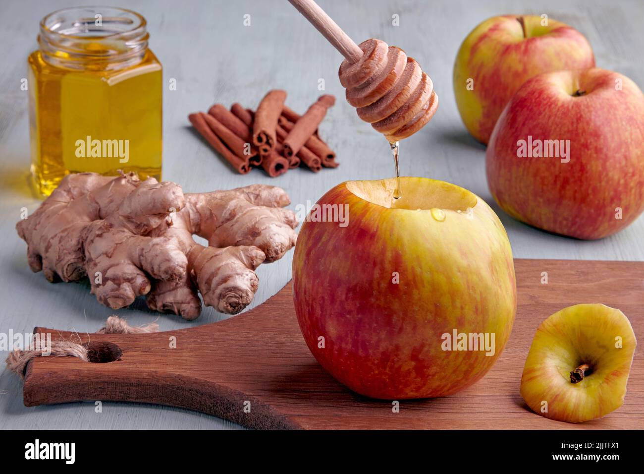 Der Apfel wurde für das Backen im Ofen vorbereitet und der Honig-Rinnsal wird von Zimt und Ingwer-Zutaten umgeben Stockfoto