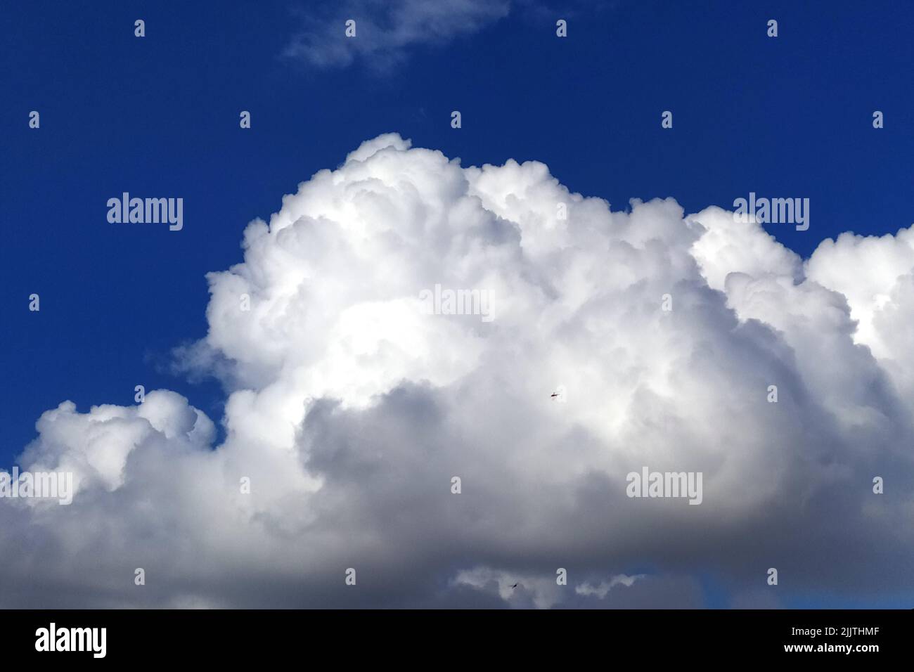 Weiße Wolken fliegen am blauen Himmel Stockfoto