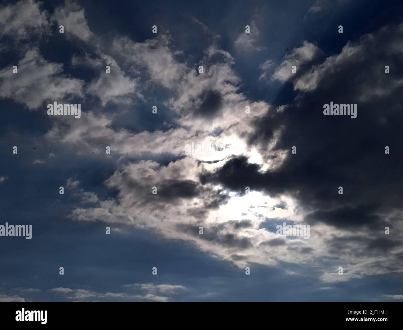 Weiße Wolken fliegen am blauen Himmel Stockfoto