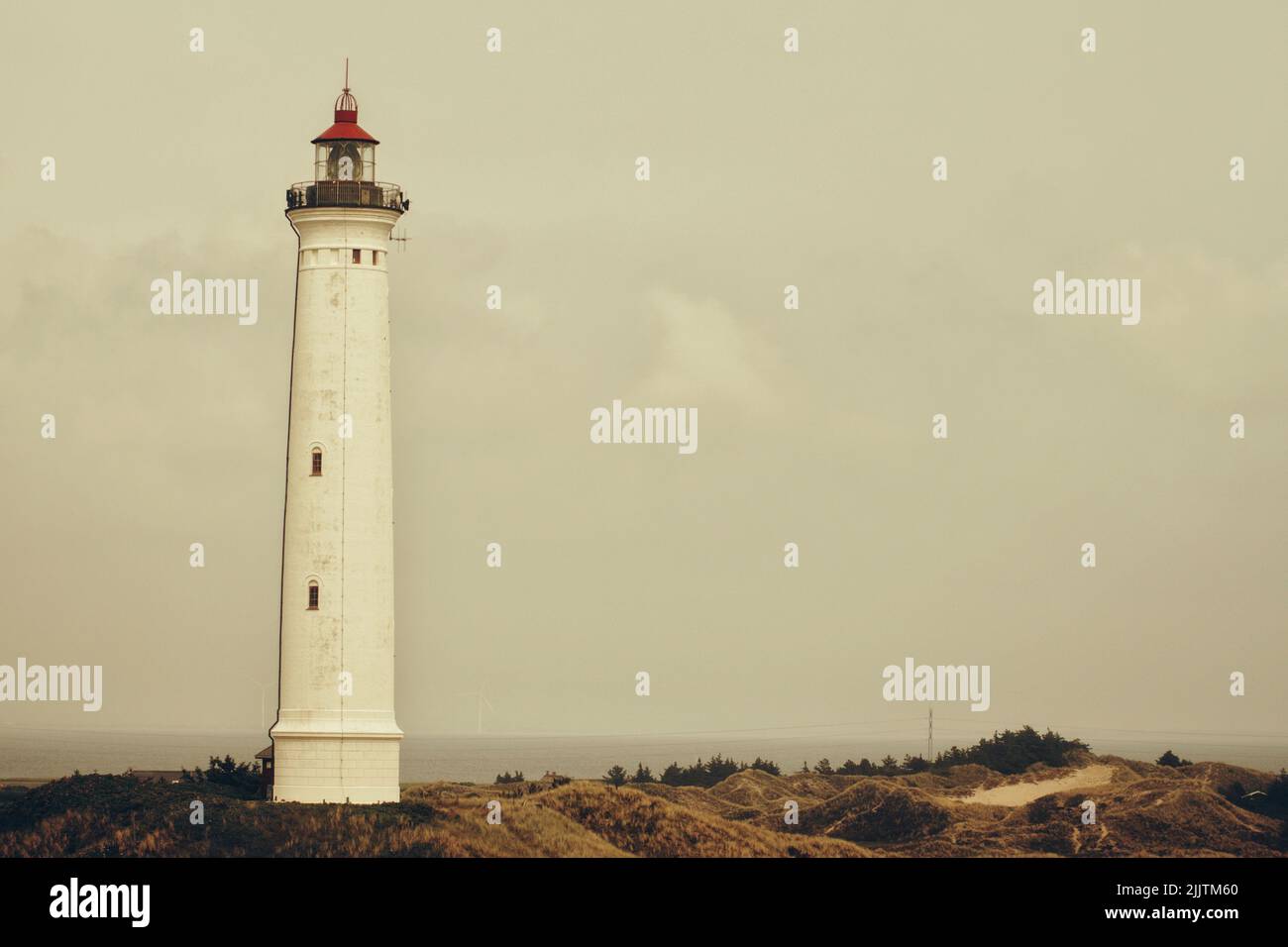 Eine schöne Aufnahme eines weißen Leuchtturms vor einem grau bewölkten Himmel Stockfoto