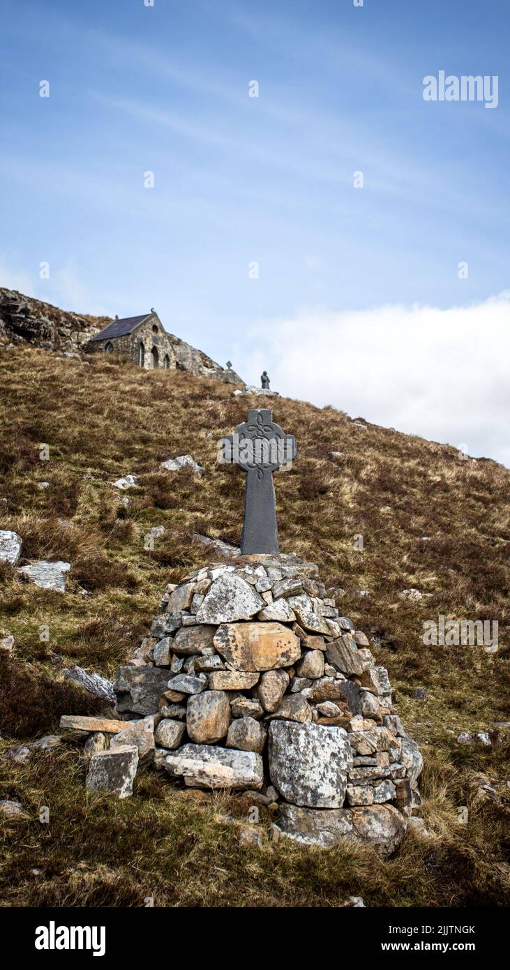 Ein Gedenkhaufen aus Steinen mit einem Kreuz auf einem Hügel Stockfoto