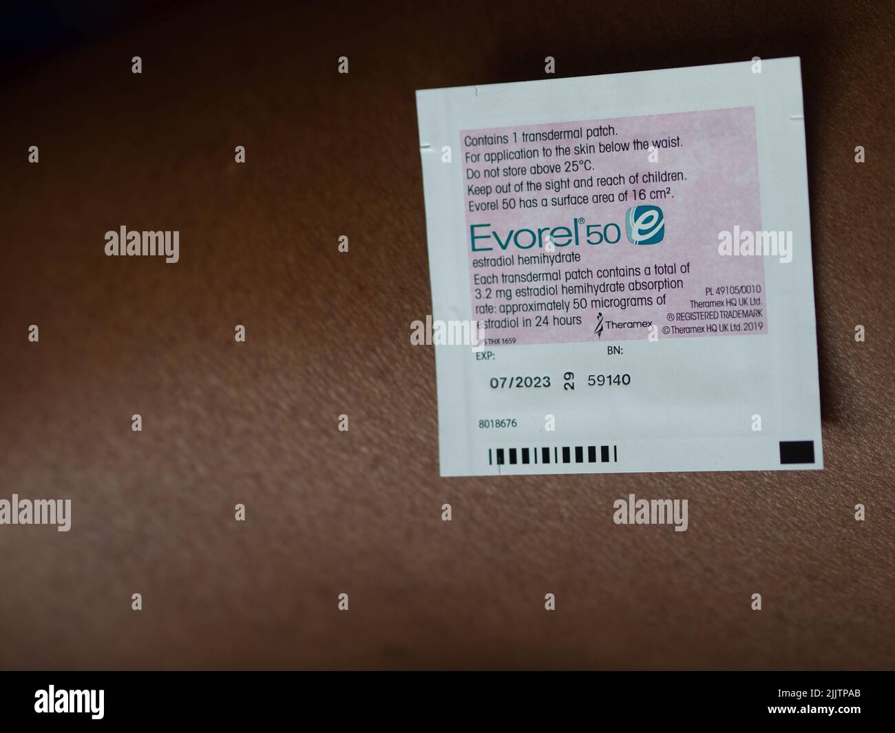 Evorel HRT Patch wird auf die Haut einer farbigen Frau gelegt Stockfoto