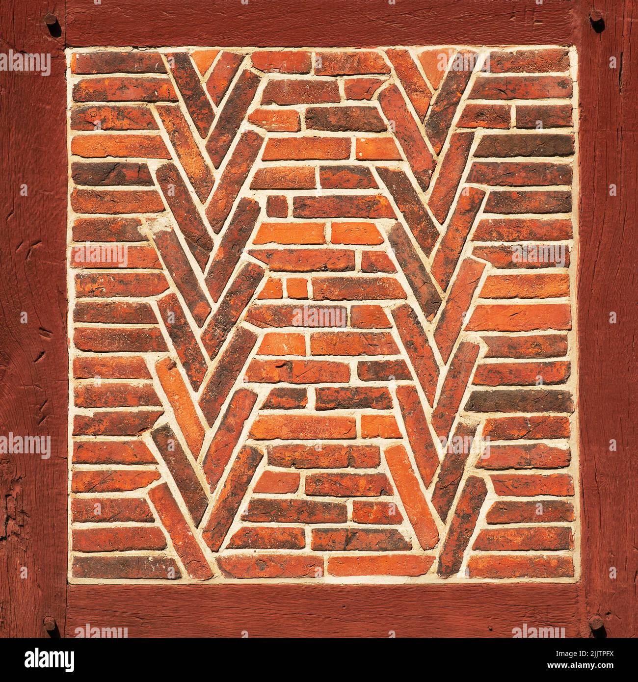 Alte rote Backsteinmauer mit Holzbalken als Textur oder Hintergrund. Architektonische Details. Stockfoto