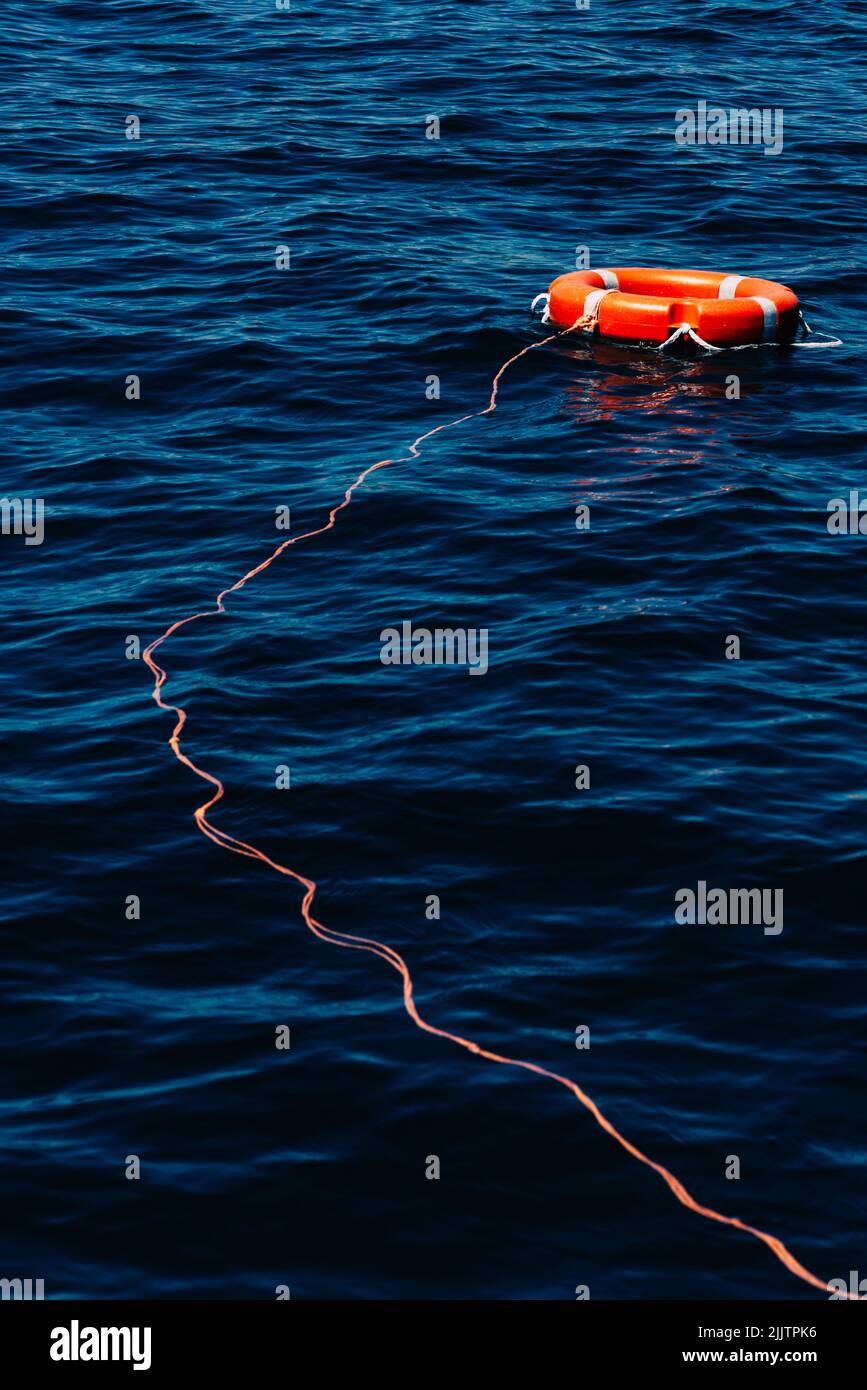 Eine vertikale Aufnahme einer roten Rettungsboje an einer Bucht der Algarve, Portugal Stockfoto