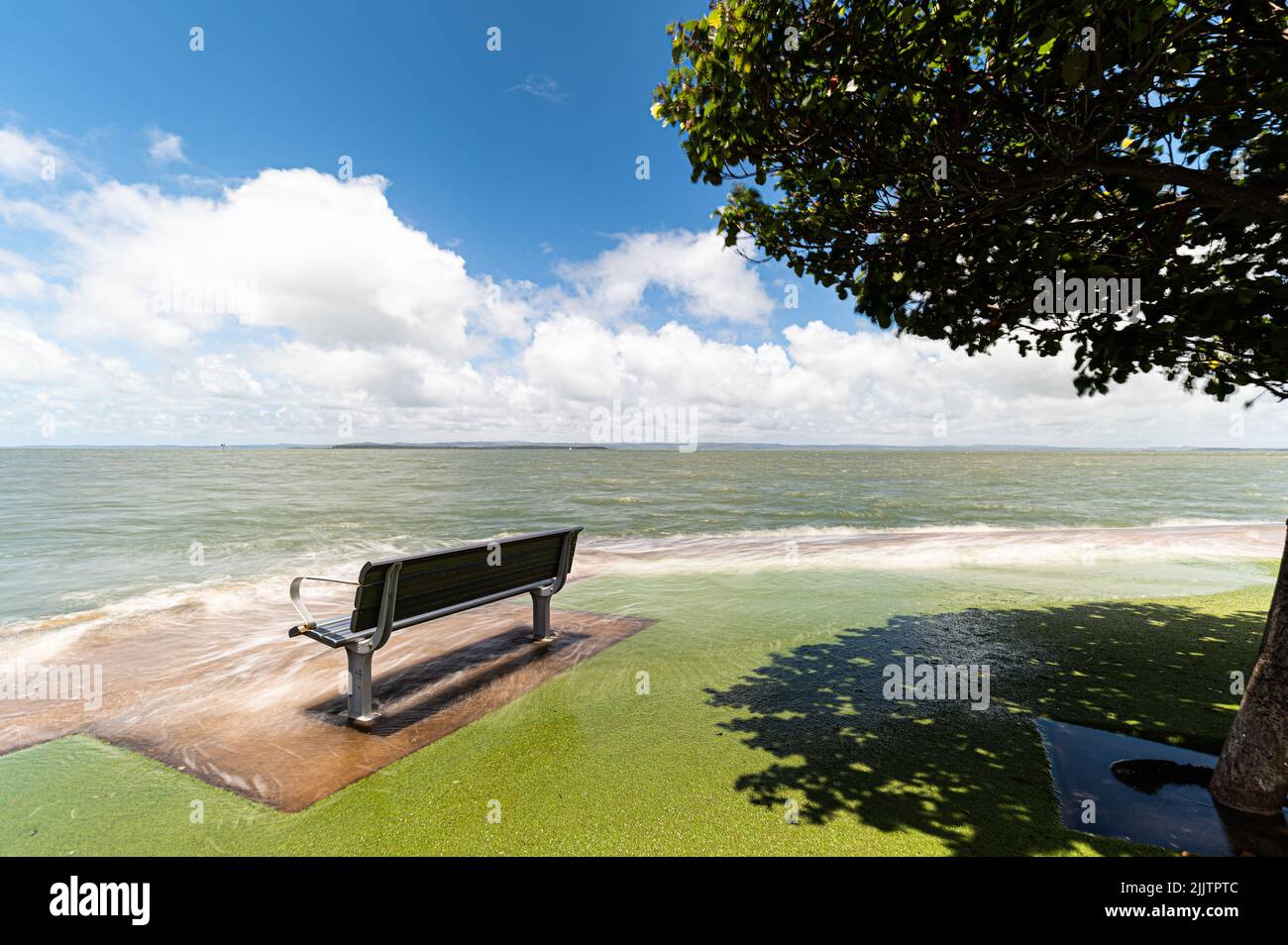 Eine Bank an einem Ufer bei extra hohen Gezeiten - Klimawandel Stockfoto