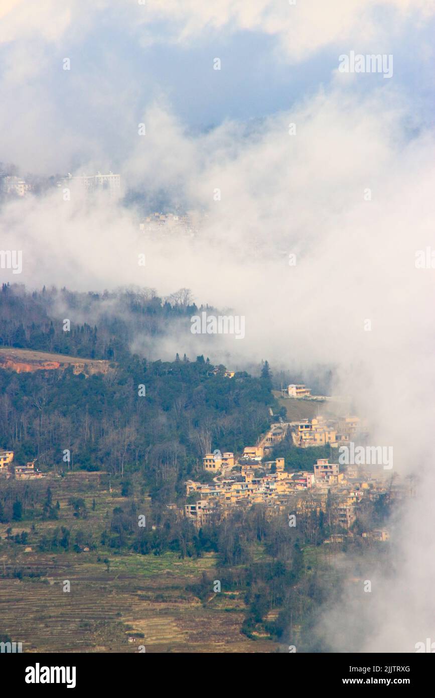 Ein Dorf im Nebel unter dem Berg Ailao Stockfoto