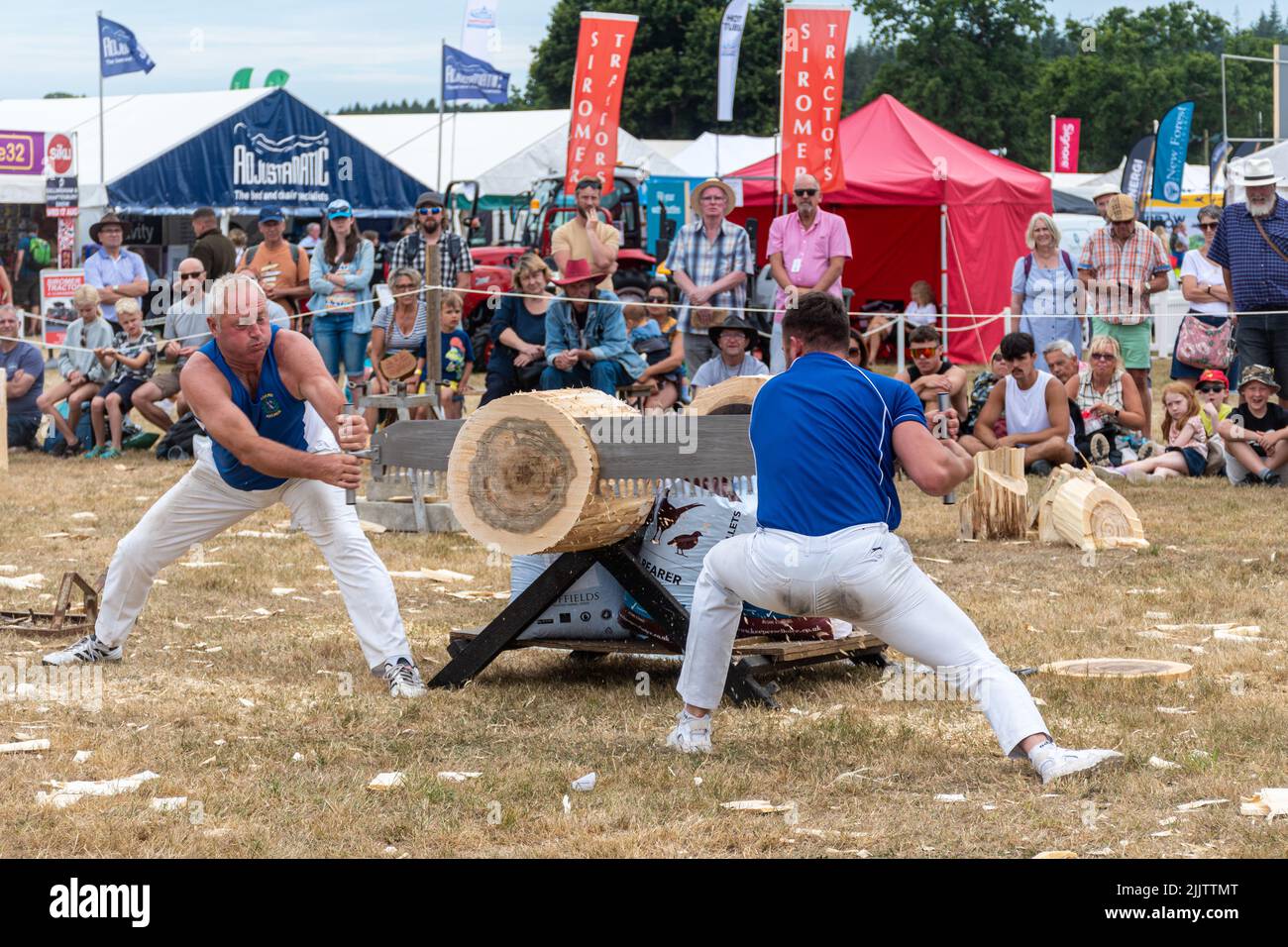 Zwei Sägegeräte, die auf der New Forest and Hampshire County Show im Juli 2022, England, einen Baum mit einer zwei-Mann-Säge schnitten Stockfoto