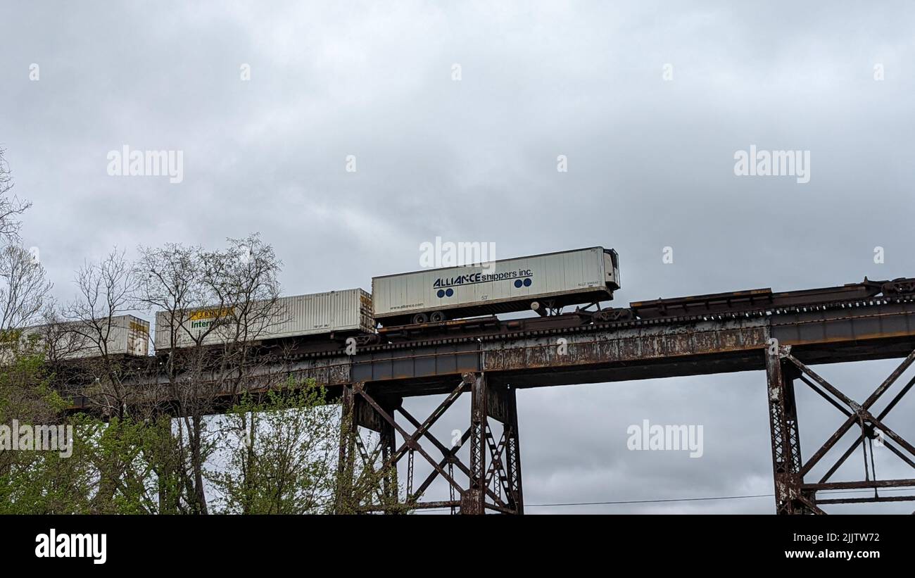 Die Zugwagen auf der Metallbrücke gegen den bewölkten Himmel. Altavista. Die Vereinigten Staaten. Stockfoto
